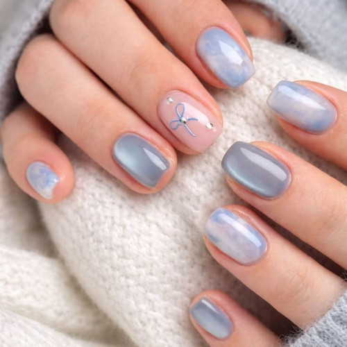 Delicate blue manicure with cat eye effect and a bow